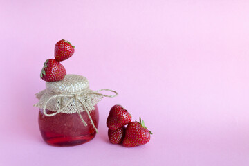 Jam. Strawberry jam, strawberries on a pink background. Copy space