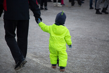 A child walks with his father along a city street on a day off