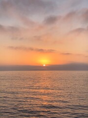 Obraz premium Golden sunset over calm ocean waters