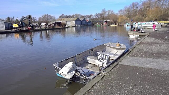 A view down the River Bure, Norfolk Broads, as captured from the riverbank in the village of Wroxham, a popular tourist destination