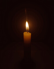 A single candle burns softly in the darkness, its golden flame flickering gentle.