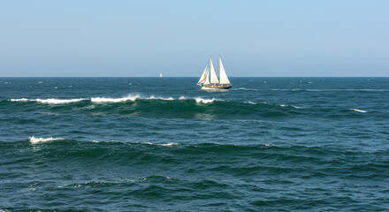 Sailboat on the Ocean with Blue Sky and Waves in a Scenic Summer Seascape