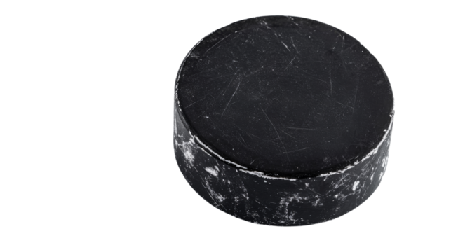 Scratched and worn hockey puck on transparent background