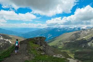 Fototapeta premium Hiker woman on rugged hiking trail with scenic view of majestic mountain peak Reitereck, Ankogel Group, Carinthia, Austria. Wanderlust in remote Lieser Malta Valley. Alpine wilderness of Austrian Alps