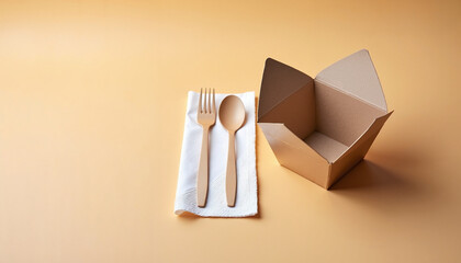 Cutlery and takeout box on beige background