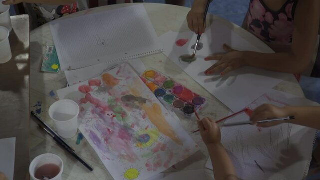 ni&ntilde;os pintando con acuarelas sobre papel