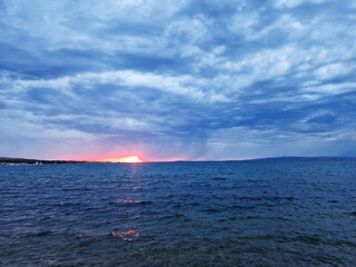 Dramatic seascape at sunset with stormy clouds and glowing horizon