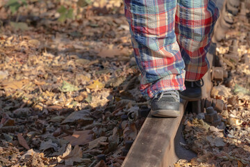 Naklejka premium Children's feet on the railway track. (concept: dangerous games)