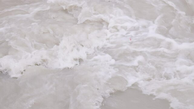 transparent plastic bottles trapped in muddy seething water in slow motion, closeup full-frame background