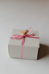 gift. White gift box decorated with pink ribbon with dried flowers