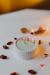 White decorative candle decorated with flowers. Spring candle collection. Home decor.