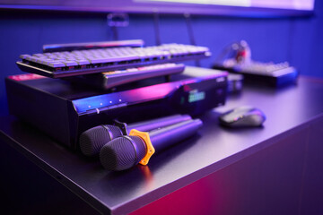 There are several colorful microphones beautifully arranged on a table in a trendy karaoke room