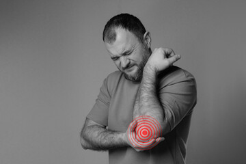 Man has elbow problems after intense physical activity, long training or professional activity....