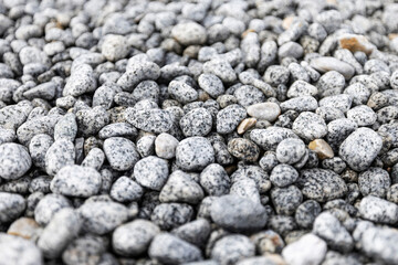 Bed of pebbles or smooth rocks and stones with light gray texture