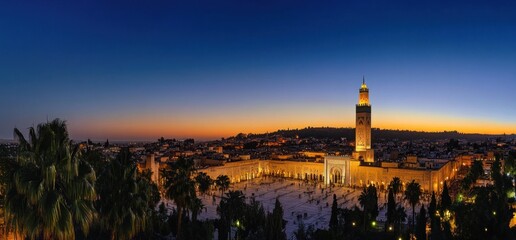 Sunset view of illuminated mosque and city.