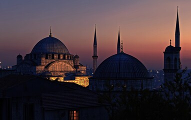 Obraz premium Sunset view of illuminated mosques and minarets.