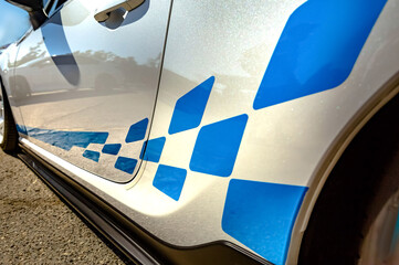 White car with blue strips and pattern closeup shot from the side