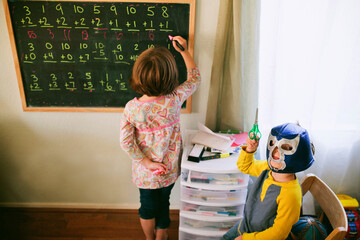 Girl doing Math, Brother with Scissors and Mask