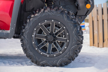 Exterior of a red car with close up view of the wheel against white sand © Jason
