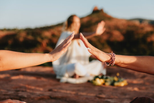 Hands almost touching with mountain in background