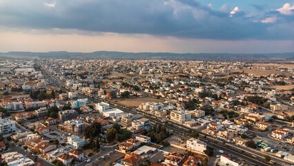 Aerial view of a sprawling urban landscape under a partly cloudy sky in Cyprus.