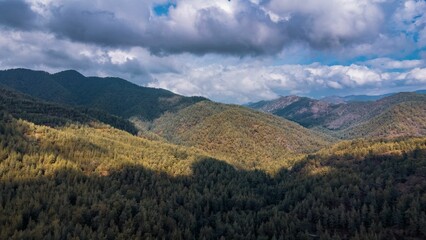 Scenic view of lush green mountains under a cloudy sky.
