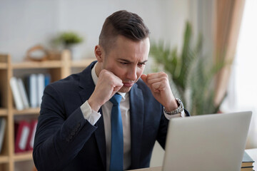 Man showing frustration while working on a laptop in a modern office environment