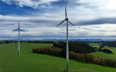 Drohnenfoto von Windrädern in einem Feld vor den Allgäuer Alpen
