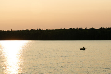 Golden hour magic over a scenic lake, with shimmering water and a peaceful sky in the background.