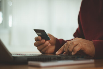 Online shopping concept. Business financial and online payment technology. Businessman holding credit card and typing on laptop for online shopping and payment makes a purchase on the internet.