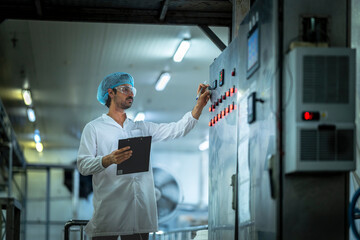 Engineer conducting equipment maintenance checks in a clean food processing plant Ensuring quality...