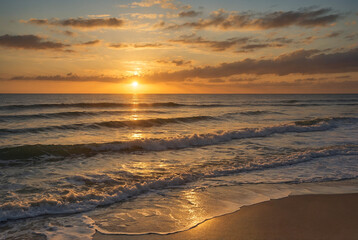Soft golden sunset over a calm ocean with gentle waves