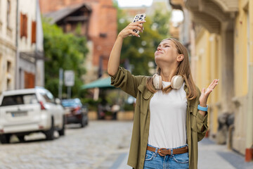 Young female tourist woman trying to catch a communication signal and Internet on mobile phone,...