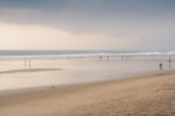 Blurry background of people at beach with cloudy at sunset