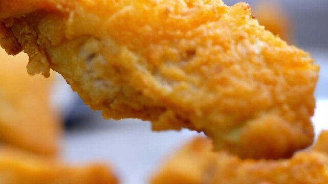 Closeup of fried chicken nuggets or broast falling on camera