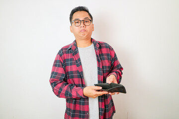 Young Asian man with empty wallet on background