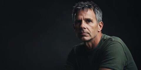 Fototapeta premium Thoughtful Man in Casual Attire Against a Dark Background