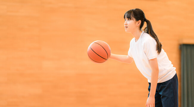 体育館でバスケットをする体操着姿の女子中学生・女子高生
