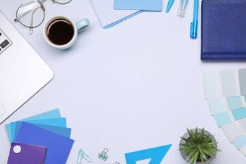 Designer's workplace. Frame of different stationery, color palettes and cup of coffee on grey...