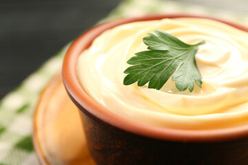 Delicious mayonnaise sauce with parsley in bowl on table, closeup