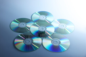 Many shiny compact discs on dusty blue background