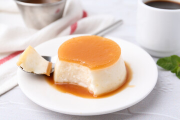 Tasty pudding with caramel sauce served on white textured table, closeup