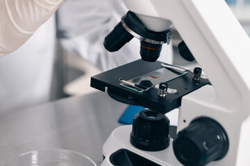 Scientist working with microscope in laboratory, closeup