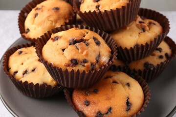 Delicious muffin with chocolate chips on table, closeup