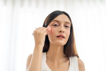 Smiling of young beautiful pretty asian woman clean fresh healthy white skin looking at camara.asian girl holding make-up brushes and make up on face with cosmetics set at home.facial beauty