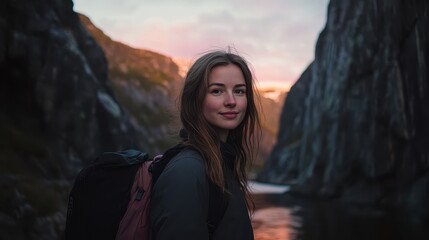 Naklejka premium Young Woman Smiling in Majestic Mountain Landscape at Sunset