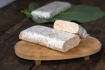 Raw Tempeh Slices on Wooden Board Background. Tempeh is Made from Fermented Soybeans