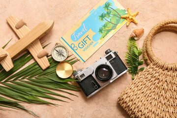 Composition with travel gift voucher, wooden plane, photo camera and beach bag on color background