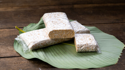 Raw Tempeh Slices on Wooden Board Background. Tempeh is Made from Fermented Soybeans