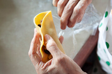Chef folding empanada dough, filling with savory ingredients